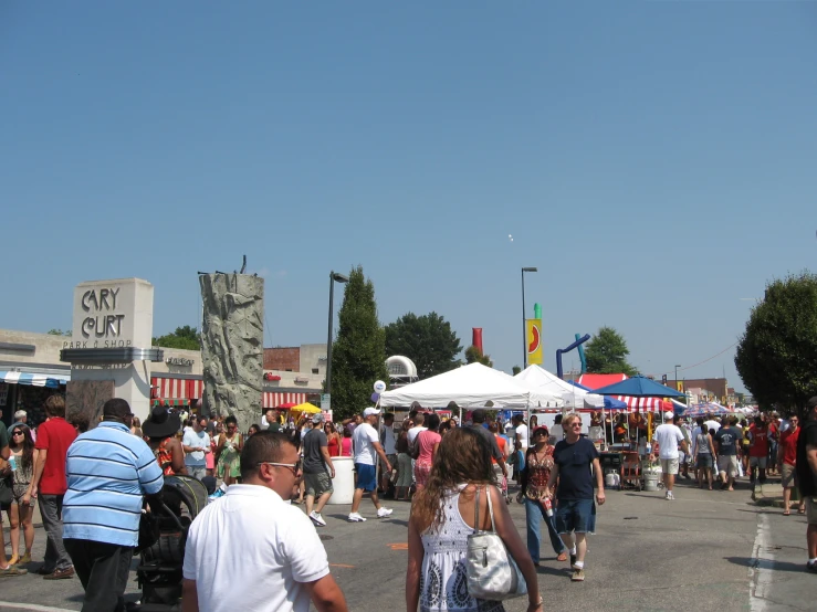 the people are walking around the open air market