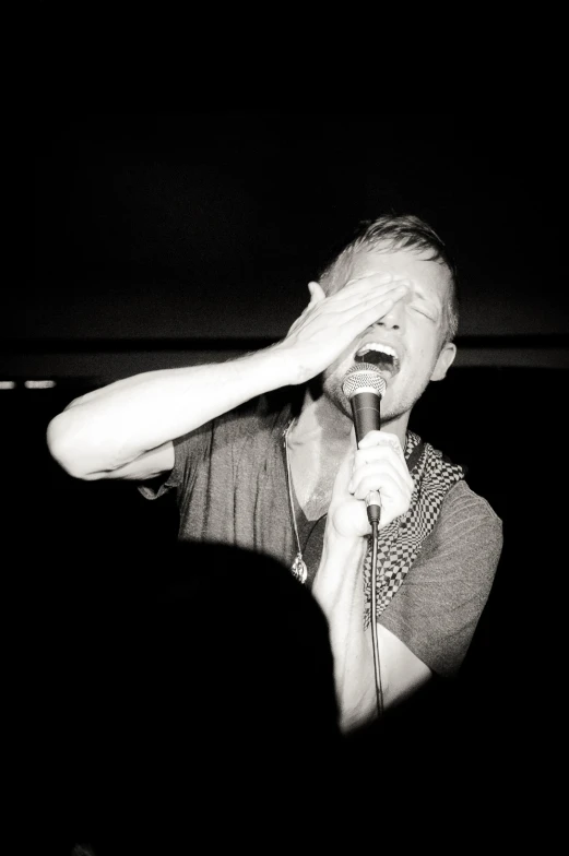 man in a concert with his hands up in the air