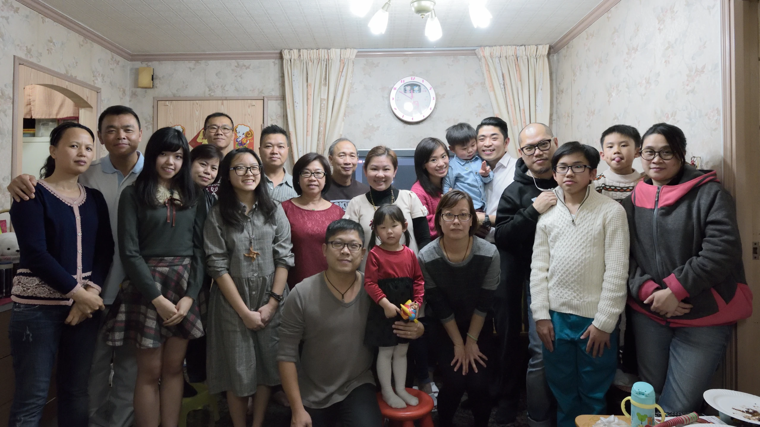 a group po of adults with young children standing in kitchen