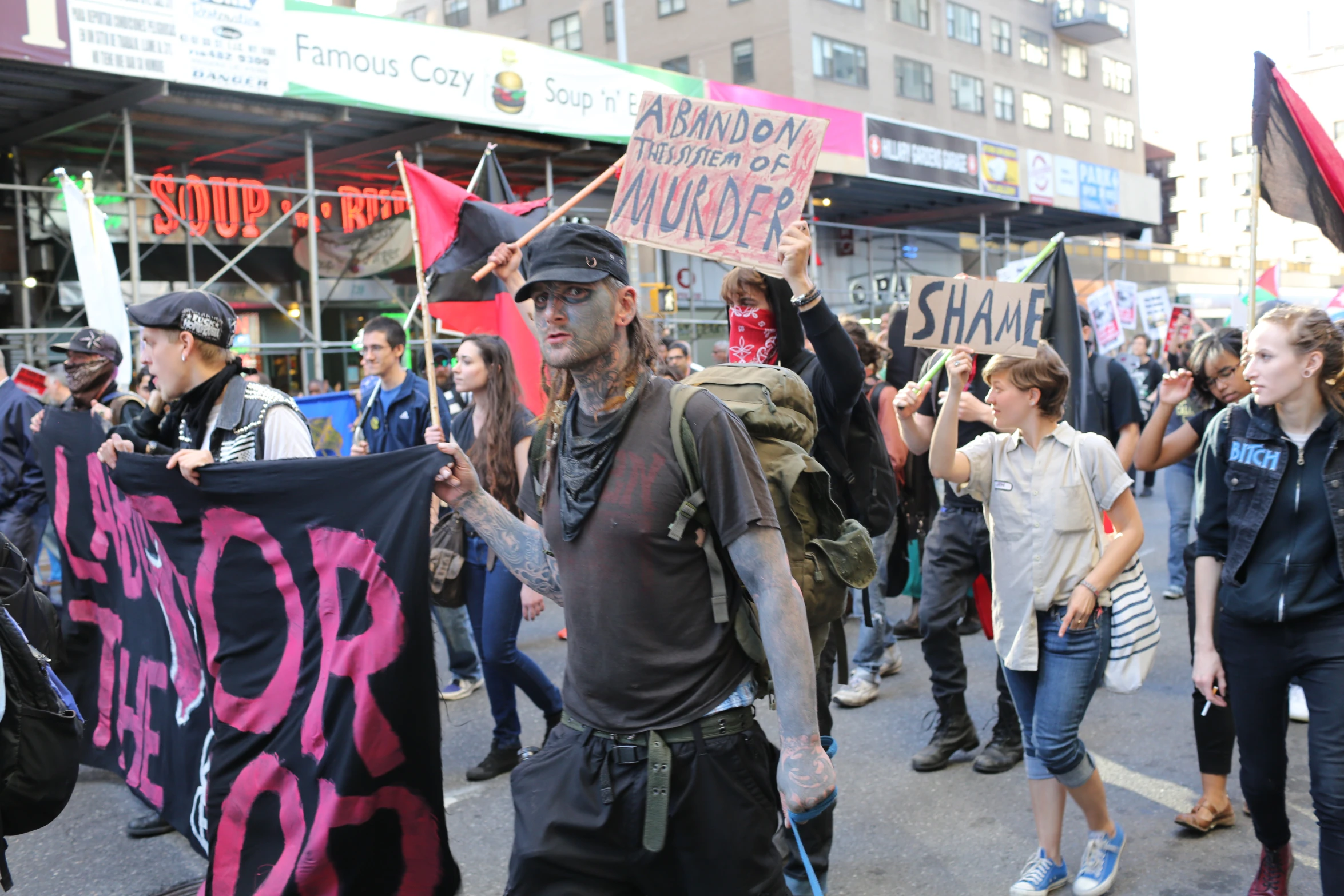 people with signs marching down the street together