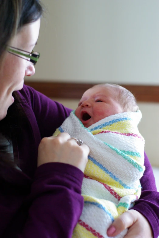 a woman holding a baby in a sling