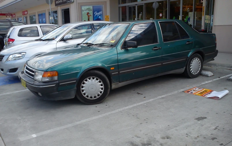 a green car parked in front of a store