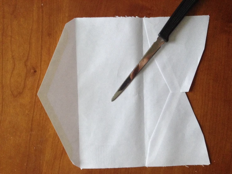 scissors sticking out of a piece of paper