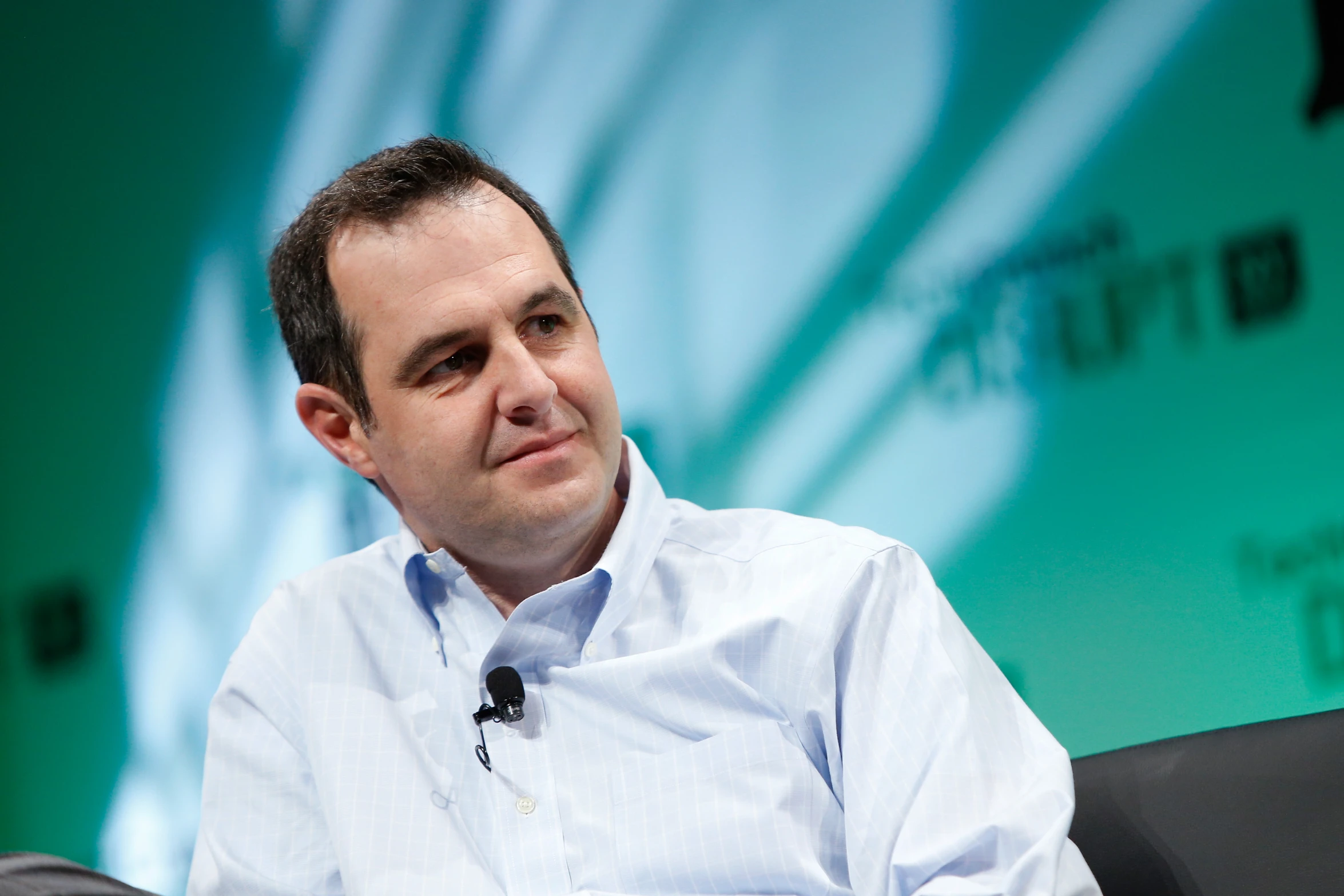 a man is sitting on a panel wearing a blue shirt