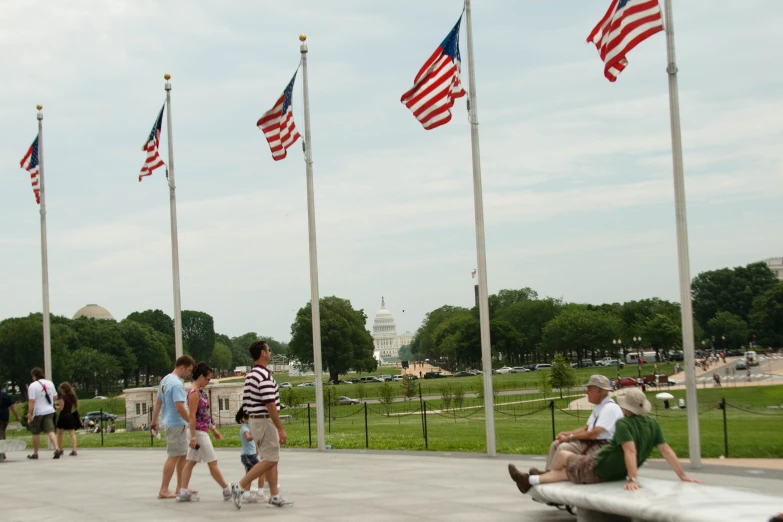 people walking around in the open in front of flags