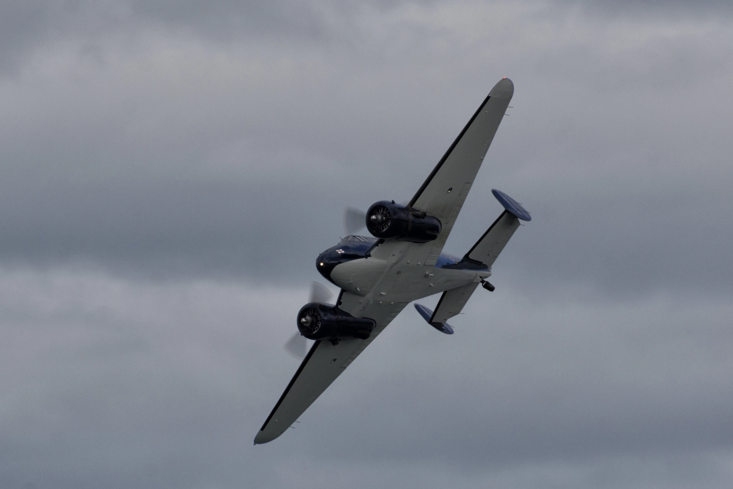 a small plane flies thru the cloudy sky