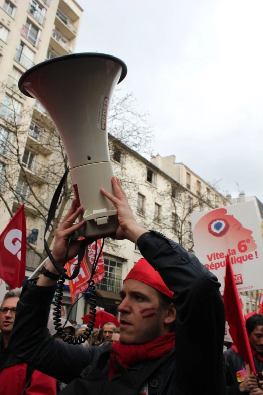 a man holds up a giant bullhorn in front of some people