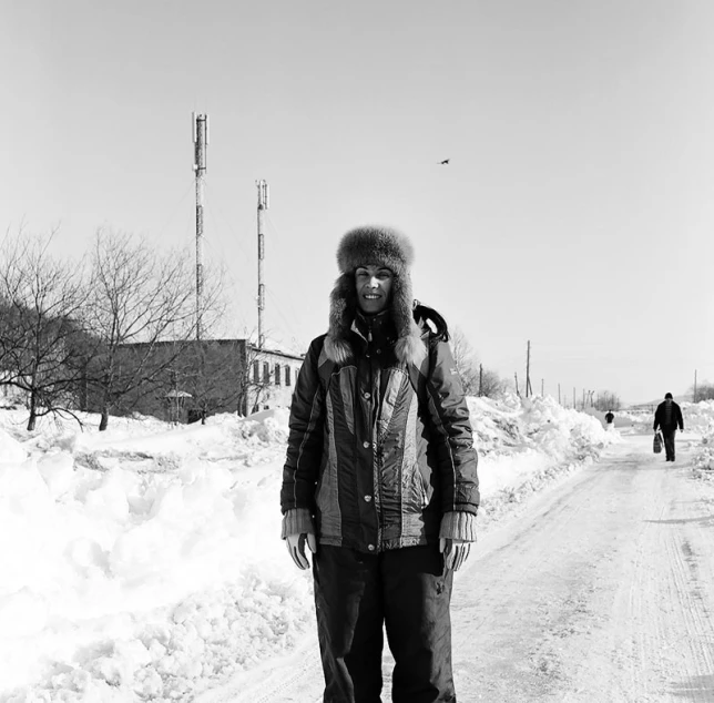 the person on skis is standing on the snow covered road