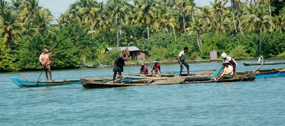 some people are standing on wooden boats in the water