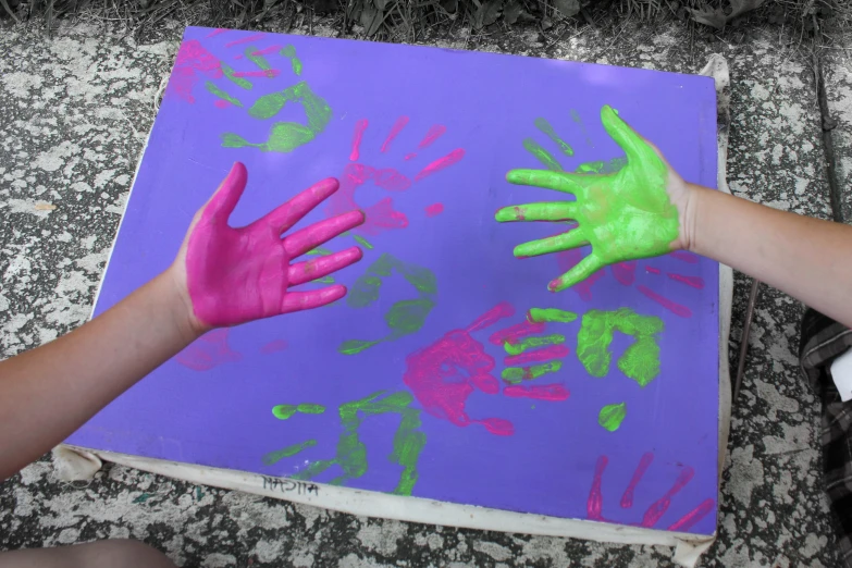 a child's hand painted on a purple canvas