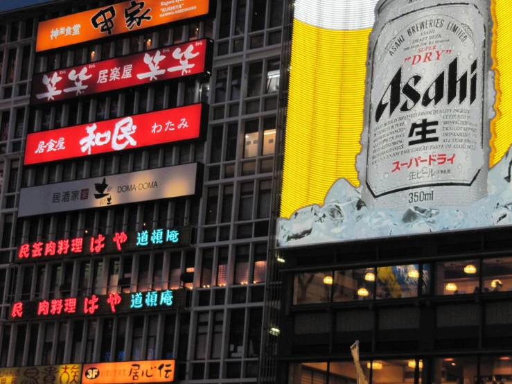 large advertising signs in a busy city by an office building