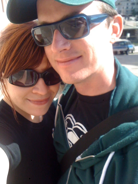 a young couple posing together with sunglasses on