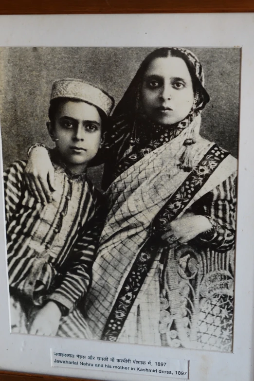 an old po with two women dressed in traditional indian clothing