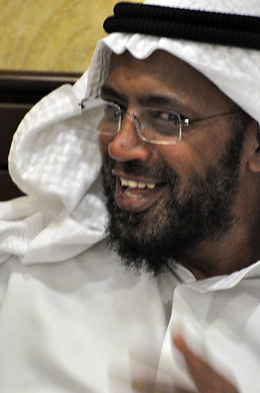 man wearing a white cloth outfit with glasses and smiling