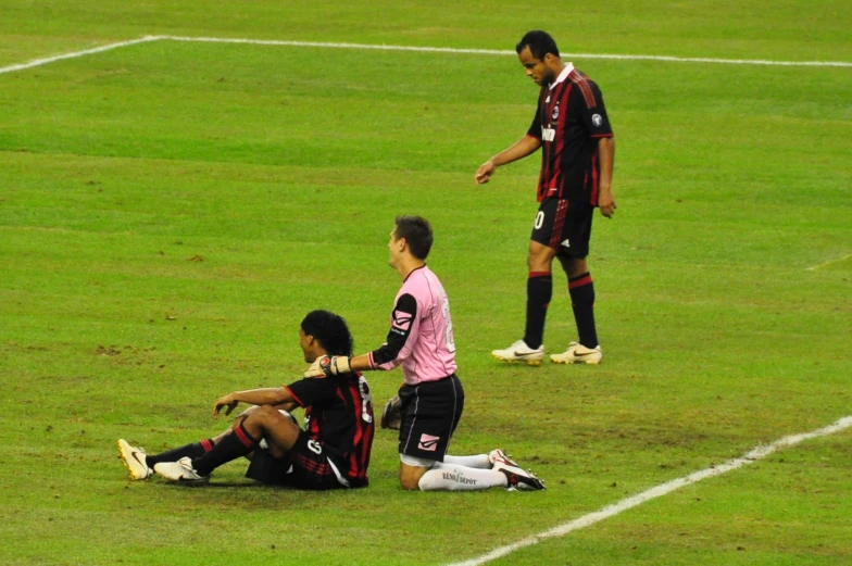 there are some people that are sitting on the soccer field