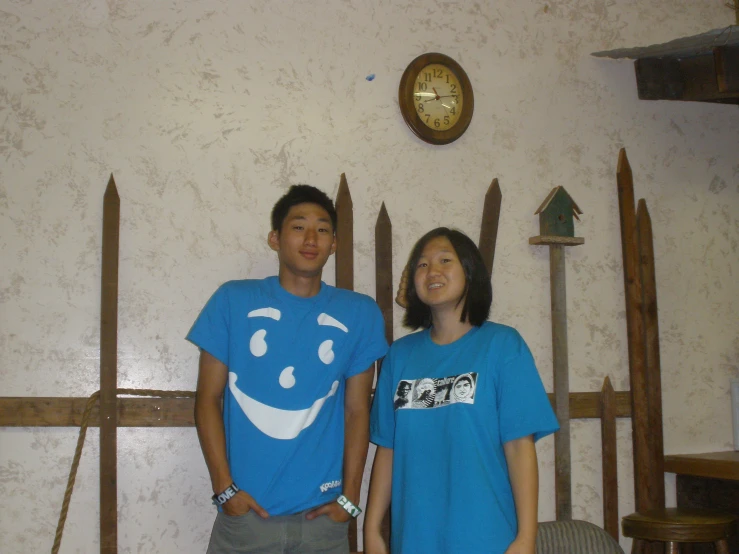 a man and woman posing for a picture next to wood boards