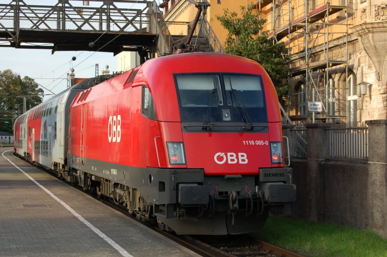 a train is sitting on the tracks near a building