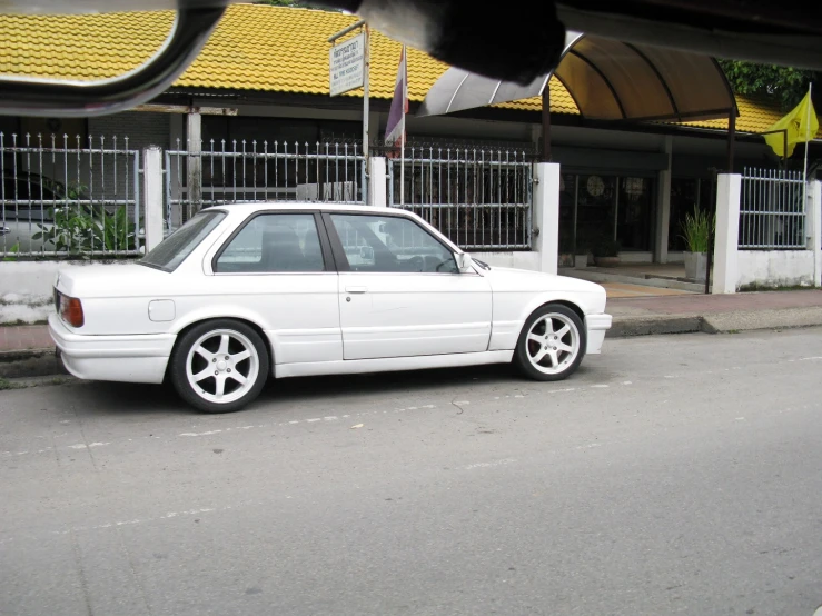 a white car parked along side of a building