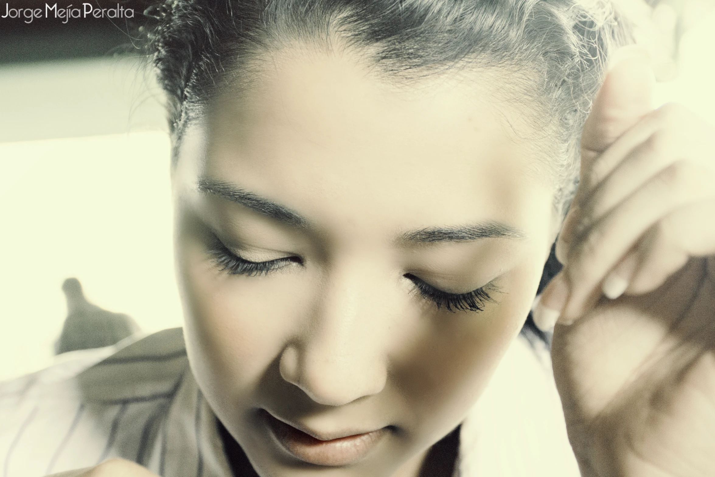 a woman with a piece of jewelry is holding her hair