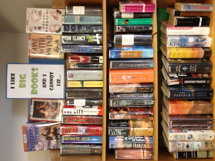 a couple shelves full of books on top of wooden shelves