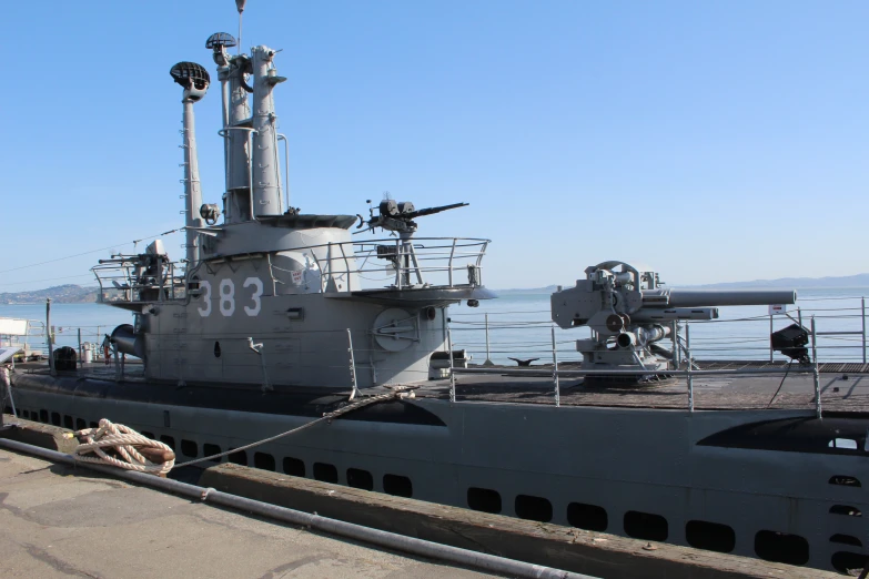 large military ships and boats docked on the water