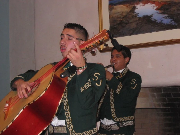 two men with musical instruments sing and play