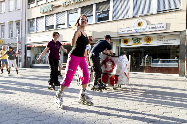 a group of young people riding skateboards down a street