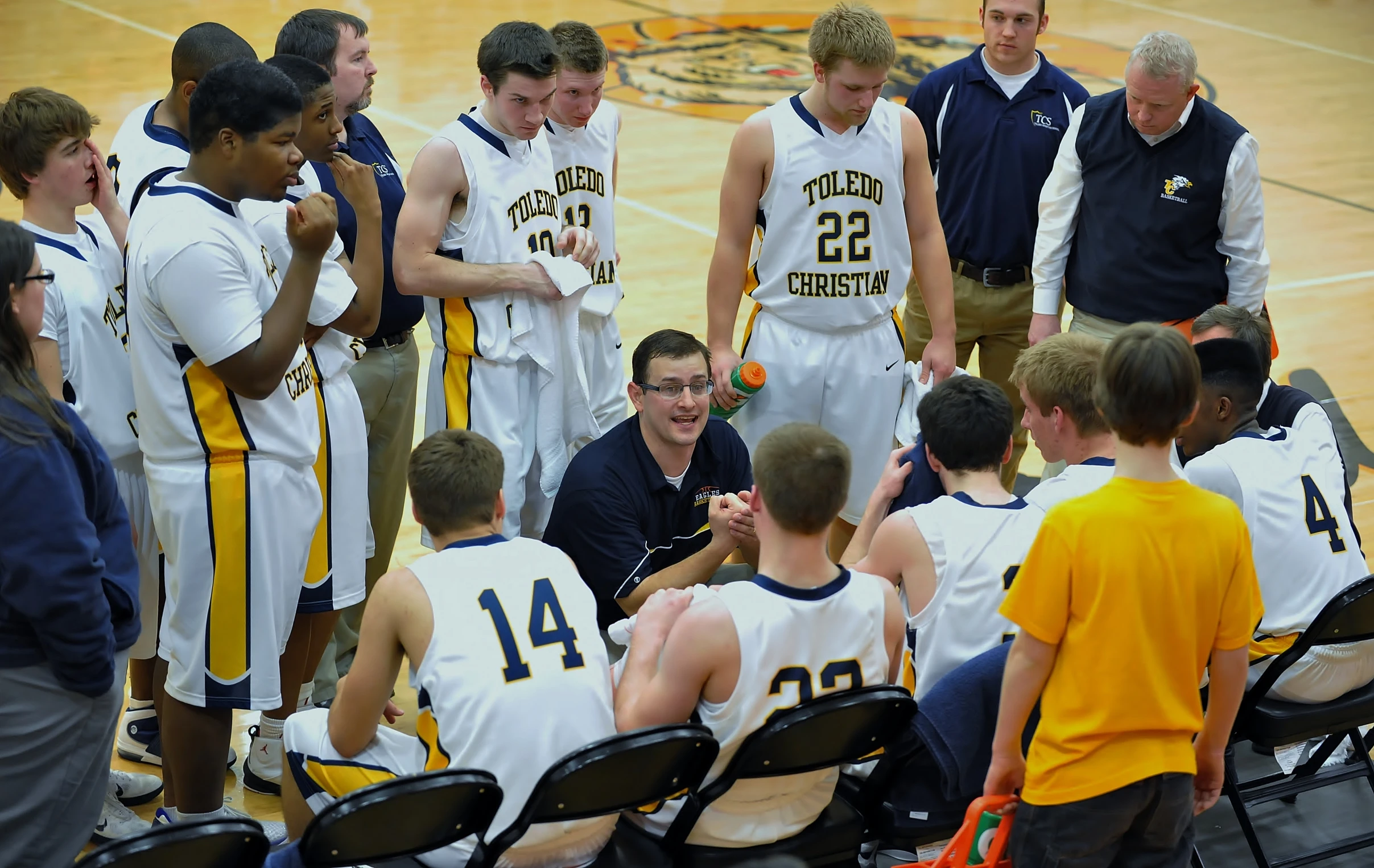 several young men standing around talking to each other on the court