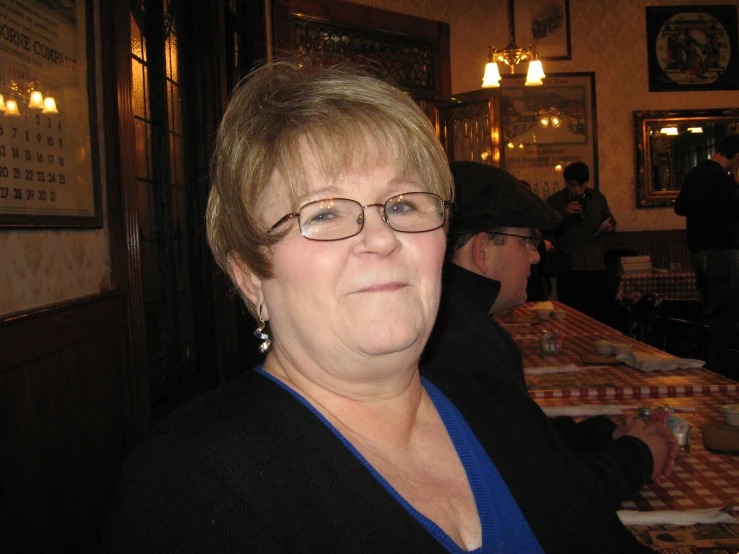 a woman is sitting in a bar while smiling