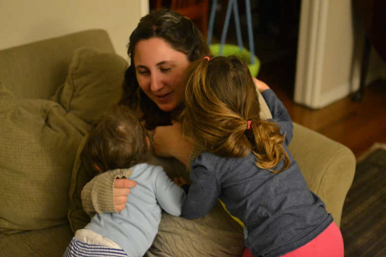 two girls and a lady playing on a couch