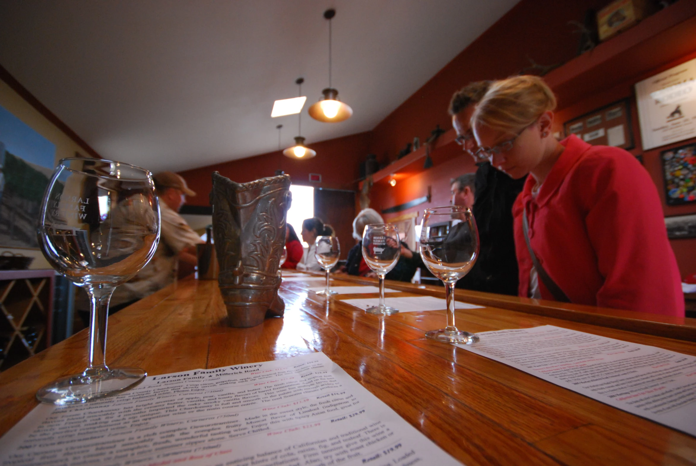 a woman in glasses sitting at a wooden bar