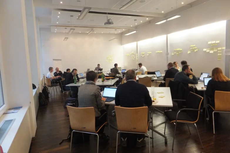 a group of people working on laptops in a conference room