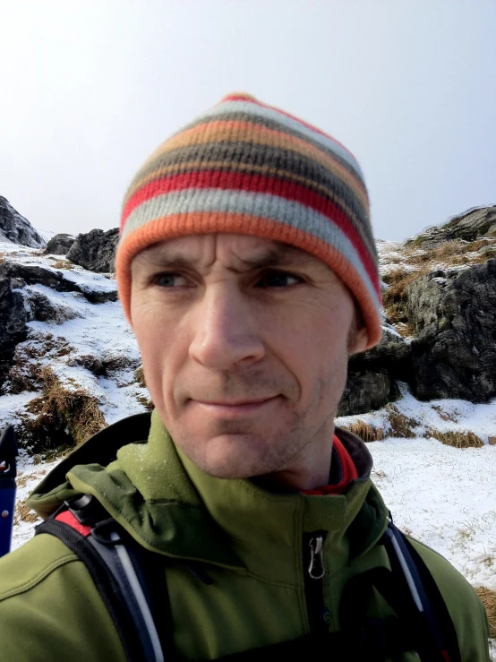 a person wearing a hat, a jacket, and some snow