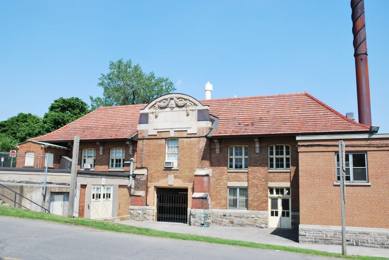 old brick building with stone fence in front of it