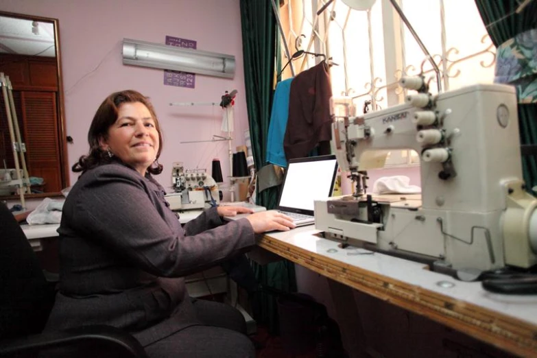 a person working on a computer at a sewing machine