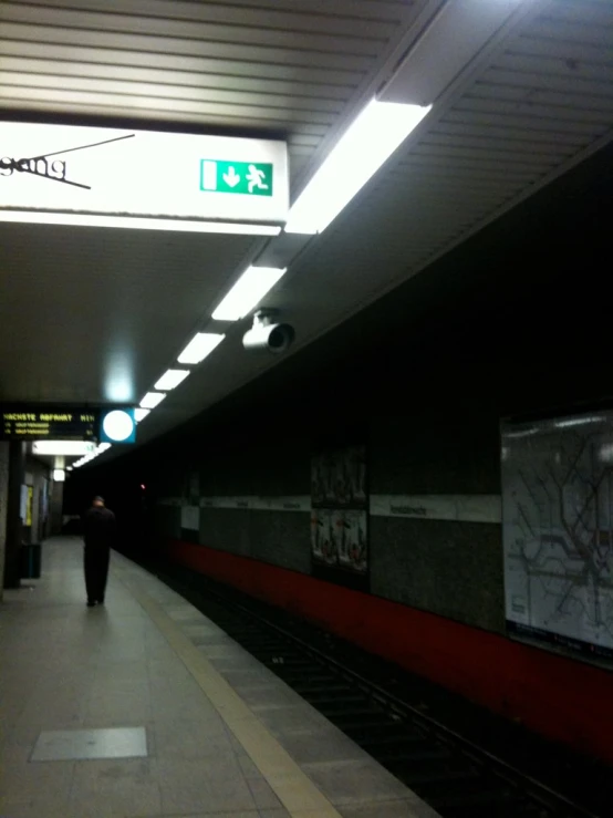 the subway station is empty with people standing near it