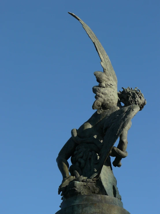 a statue with an umbrella and a winged figure holding a ball