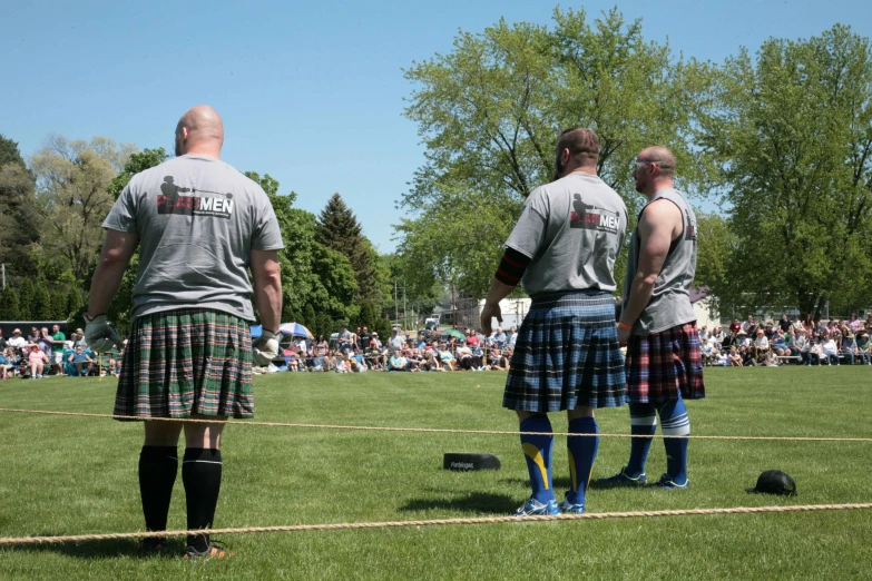 the men are wearing tartans and kilts for a ceremony