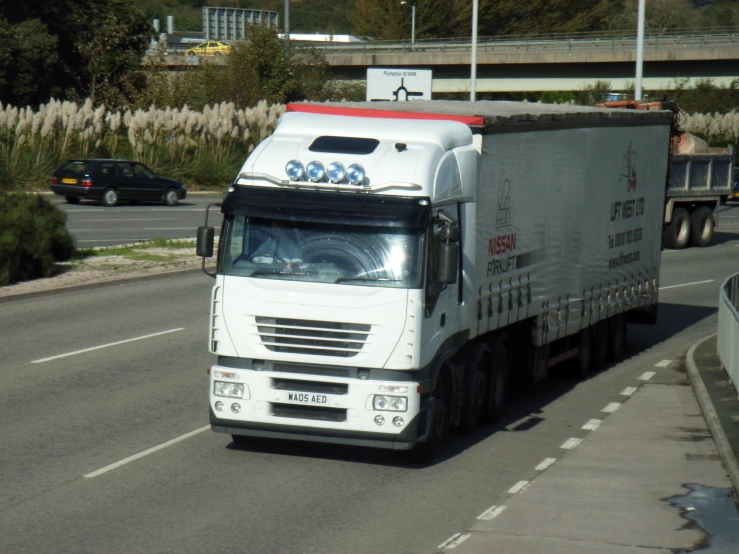 the truck is driving down the street near a highway