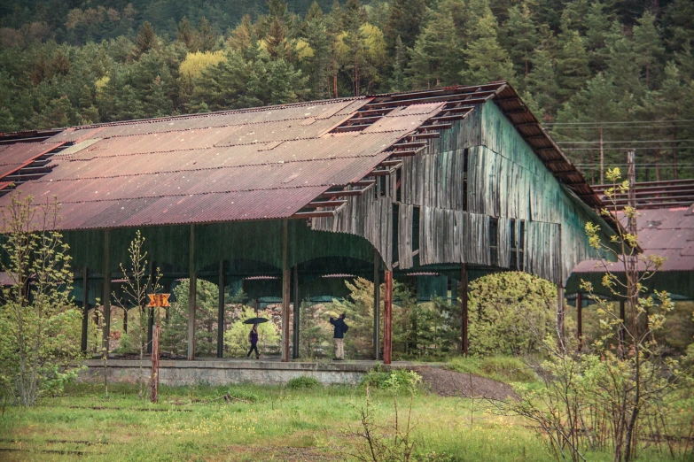 a rusted up old metal barn with a covered porch