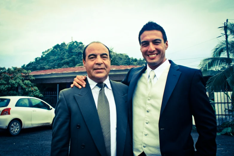 two men dressed in suits standing next to each other