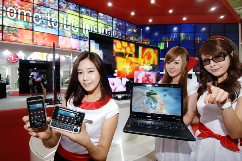 a bunch of girls show off some electronic devices