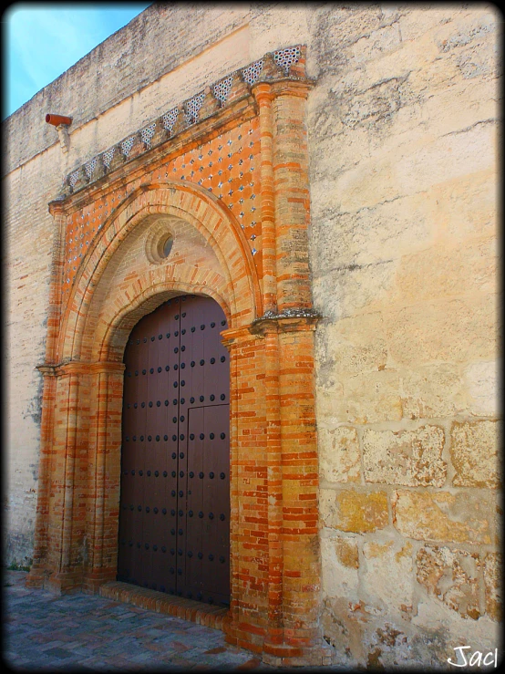 a door in a stone wall with a brown wood handle