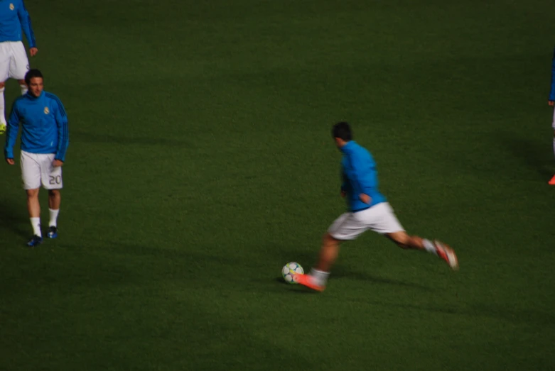 a soccer player runs with the ball in his hands