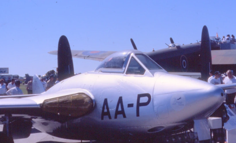 an airplane with people around it sitting on the ground