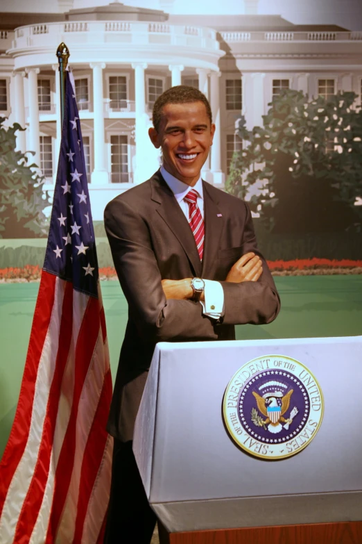 a man posing for a picture with a podium next to a flag