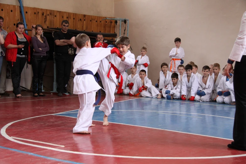 people watching a man perform martial moves on the floor