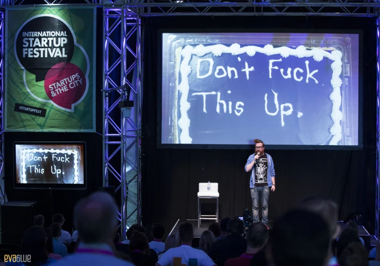 man standing in front of stage giving a presentation