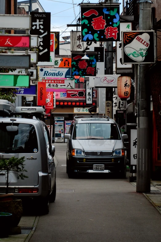 two cars parked on the side of a busy street