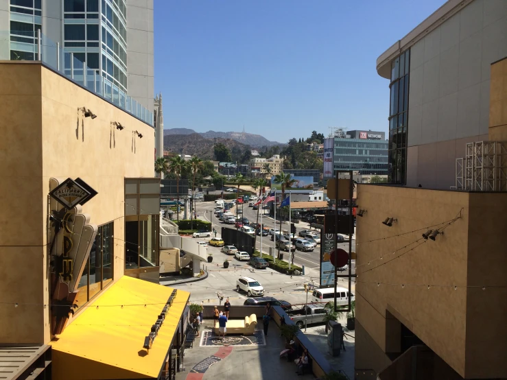 a city view with the surrounding buildings, trees, cars and a yellow table